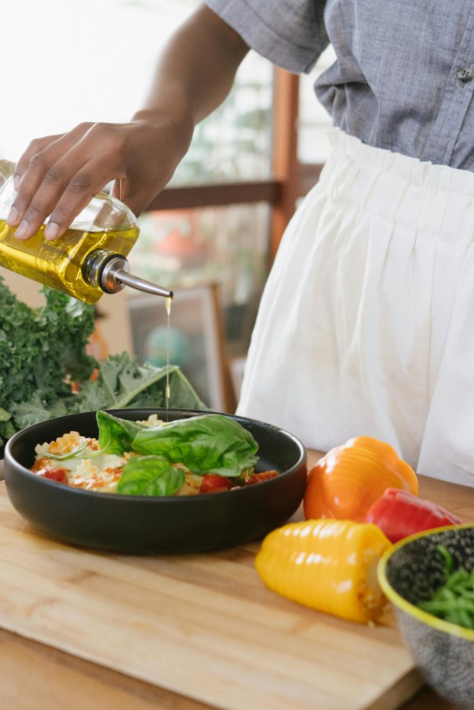 Woman pouring oil over salad bowl, easy quick meals for one person